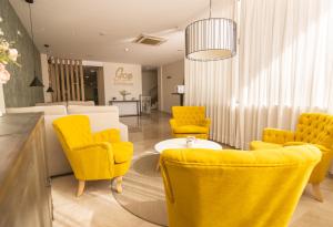 卡尔塔马格赛酒店的一间设有黄色椅子和桌子的等候室