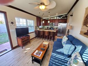 可可比奇Hawaiian Cottage - Heated Pool Walk to the Beach的一间带蓝色沙发的客厅和一间厨房