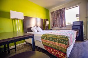 斯威特沃特Marifah Inn Sweetwater的配有一张床和一张书桌的酒店客房