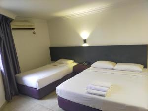 芙蓉Seremban Inn的两张位于酒店客房的床,配有毛巾