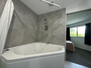 陶波贝科特湖滨汽车旅馆的带窗户的浴室内的白色浴缸