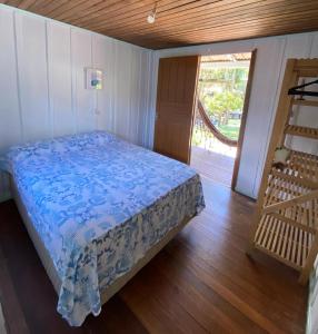 蜜岛Quartos Casa da Ilha do Mel - Nova Brasília的一间卧室配有一张床,铺有木地板
