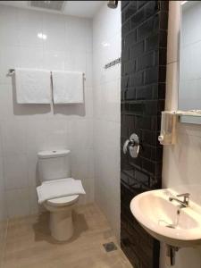 棉兰Odua Golden Mansyur Medan的白色的浴室设有卫生间和水槽。