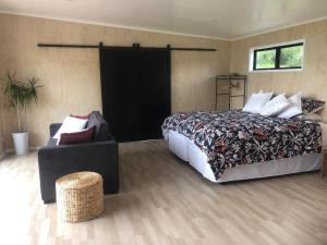 陶波Whakaipo Bay Cabin Retreat Taupo的一间卧室配有一张大床和一把椅子