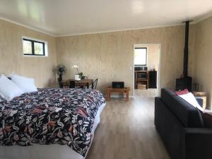 陶波Whakaipo Bay Cabin Retreat Taupo的一间卧室配有一张床和一张沙发