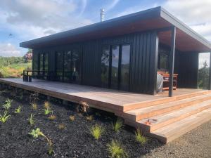 陶波Whakaipo Bay Cabin Retreat Taupo的一座小房子,在田野上设有木甲板