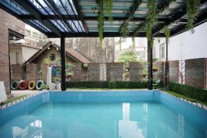 下龙湾Private room in Halong center-Almor Homestay的一个带凉棚和蓝色海水的室内游泳池