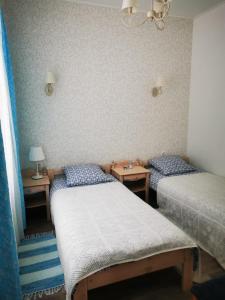 罗亚Piejūras apartamenti STEAMER的带2张桌子的客房内的2张单人床