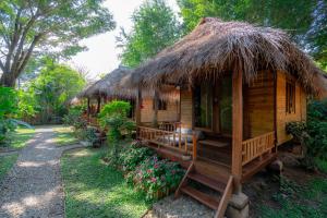 拜县Pai Village Boutique Resort的小屋设有茅草屋顶。