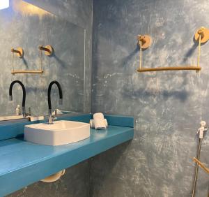 卡莫辛Pousada La Grécia的一间带水槽和蓝色台面的浴室