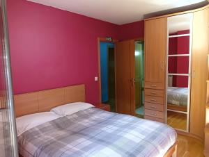 潘普洛纳La Terraza de Zahara的一间卧室配有一张床和紫色的墙壁