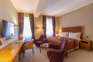 科托尔瓦尔达尔酒店的酒店客房,配有一张床、一张桌子和椅子