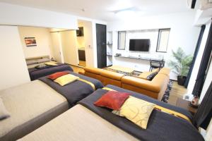 那霸菲力西塔那霸公寓的客房设有三张床、一张沙发和一台电视。