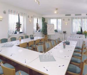 Ockenheim奥肯海姆酒店的一间设有白色桌椅的房间和一间配有桌椅的房间