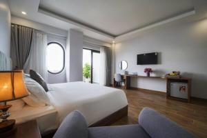 富国The May Phu Quoc Hotel的酒店客房设有一张大床和一台电视机。