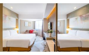昆明昆明中心假日酒店的酒店客房,设有两张床和镜子