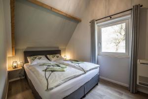 BornerbroekVakantiehuis in een prachtige bosrijke omgeving in Twente!的一间卧室设有一张大床和一个窗户。