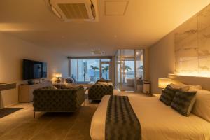宫古岛Ronsard Resort IRABU的酒店客房,配有一张床和两把椅子