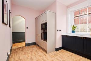 温彻斯特No2 St Peters Street的厨房设有白色的墙壁、黑色的橱柜和窗户。