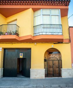 比利亚罗夫莱多APARTAMENTOS SAN ANTON的黄色的建筑,设有阳台和两扇门
