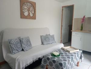 蒂约那因沃娜迪瑞特露营地的客厅配有带枕头和桌子的白色沙发