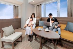大阪唐草鼎盛酒店新大阪的坐在沙发上的一个家庭