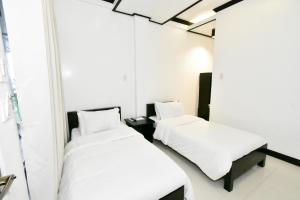 爱妮岛金丝燕酒店 的配有2张床的带白色床单和枕头的客房