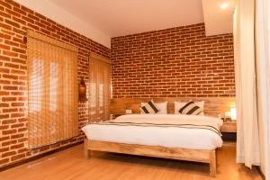帕坦KGH Patan的一间卧室设有砖墙和一张床