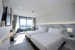 那空拍侬府VELA DHI Nakhon Phanom的酒店客房设有两张床和电视。