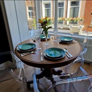 布雷达De Cosy Barock met gezellige Patio !的一张桌子,上面有盘子和玻璃杯,花瓶