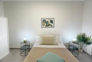 贝尔帕索Casa Lulu的一间白色卧室,配有一张床和两把蜡烛