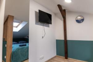 拉多姆Uroczy, przytulny apartament poddasze的卧室配有一张床,墙上配有电视。