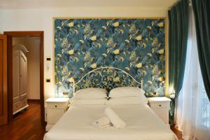 泰塞拉Venicegreen Agriresort的一间卧室配有一张带花卉壁纸的大床