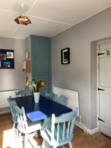 利默里克Katie’s Cottage的一间配备有蓝色桌子和椅子的用餐室