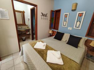 戈亚斯州上帕莱索波萨达瑞坎托格兰达巴斯酒店的一间卧室配有一张大床和两条毛巾