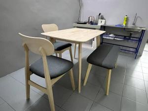 Malim NawarHomestay Malim Nawar的厨房里配有一张木桌和两把椅子