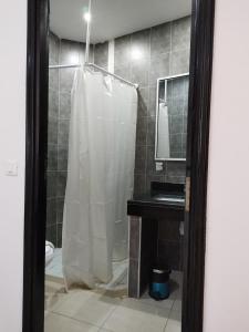 DjerbaHOTEL OLYMPIC DJERBA的带淋浴和浴帘的浴室