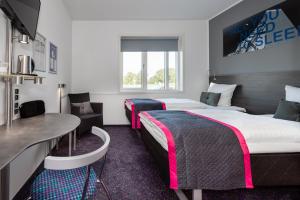 奥尔堡奥尔堡卡宾酒店的酒店客房设有两张床和一张桌子。