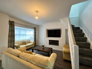 HordenBelsay 4 bedroom bungalow with loft conversion的带沙发和楼梯的客厅