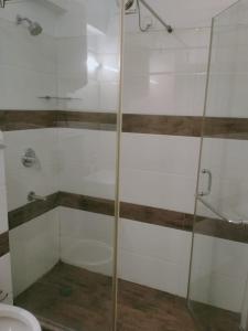 新德里Green Lotus La Wisteria Inn的浴室设有玻璃淋浴间和卫生间