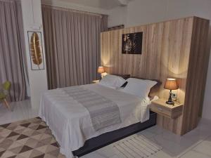 Calodyneluxury cheerful 4 bedrooms villa in Calodyne的一间卧室配有一张大床和木制床头板