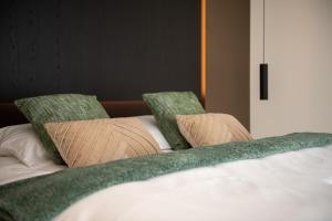 迪克斯梅德Yzerdyck的一张带两个枕头的白色床和绿色床单