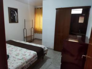 巴西利亚Angel Locação de Quartos的一间卧室配有一张床、一个梳妆台和一扇窗户。