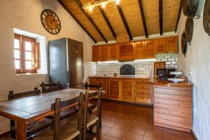 摩亚Casa Rural El Majano的厨房配有木桌和冰箱。