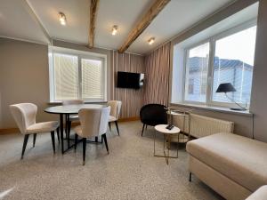 DobeleApartments in Dobele city center - Pilsētas Māja的配有桌椅和沙发的房间