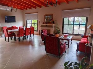 萨尔塔Las Tres Marías的客厅配有红色椅子和餐桌