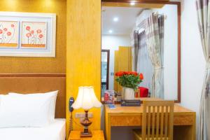 河内Moon Hotel Cau Giay的一间卧室配有一张床和一张带台灯的书桌