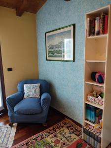 维罗纳自由镇Lovely Casa Paola的书架房间的一张蓝色椅子
