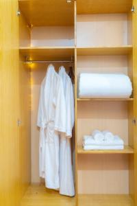 河内Moon Hotel Cau Giay的衣柜配有白色浴袍和毛巾
