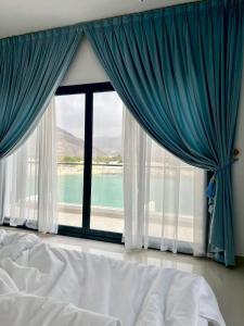 富查伊拉Iconic 4-bedroom villa with pool in Fujairah Palm的一间卧室设有大窗户,享有水景